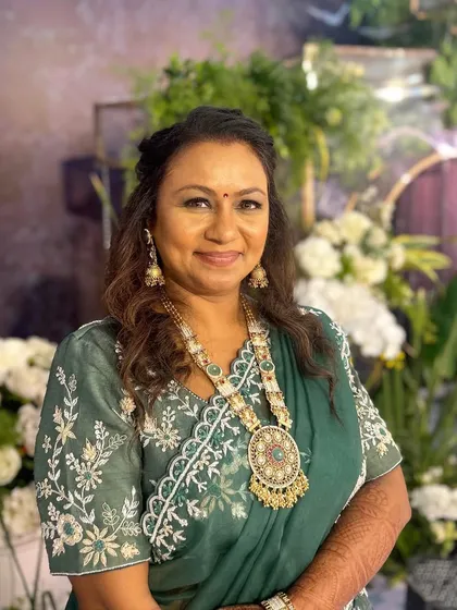 A close-up of this elegant look. The makeup is natural yet refined, letting her stunning jewelry and outfit take center stage.