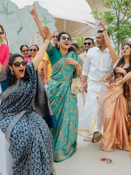 The sheer joy of a wedding celebration. A group of guests enjoying a musical game during a South Indian wedding event.