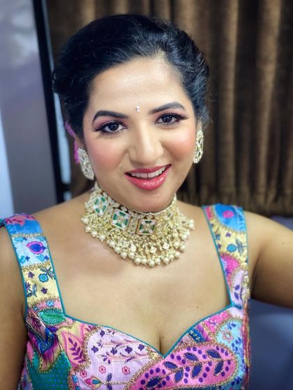 A close-up of Kavya's party makeup. The look is bright and fresh, with pink-toned eyeshadow and a glossy lip.