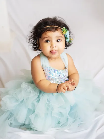 This little princess in her beautiful blue tulle dress is just adorable. The simple white background keeps all the focus on her.