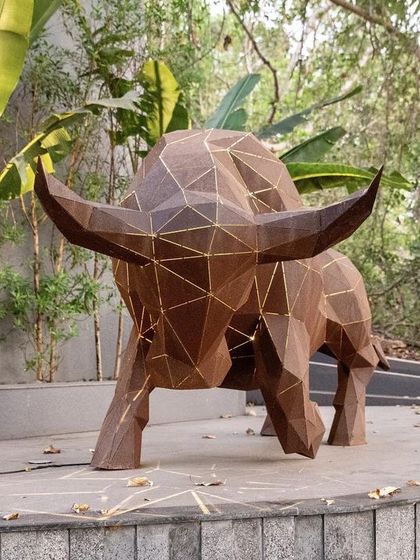 A powerful origami-inspired bull sculpture, crafted from metal with illuminated lines. This piece stands as a bold statement at the entrance to a property, blending art, light, and landscape.