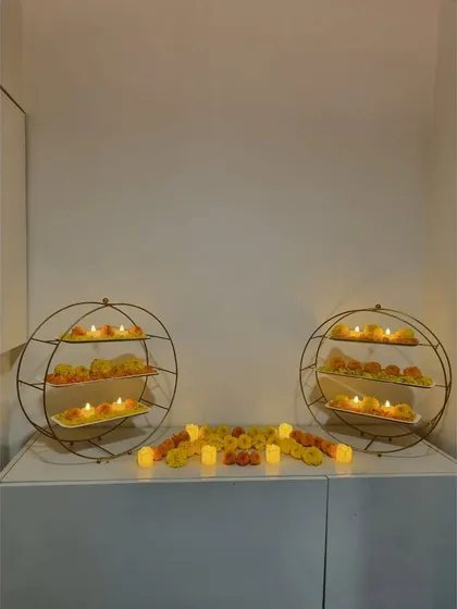 Simple yet beautiful decor for a small home event. We used circular shelves to display floral arrangements and candles, creating a lovely focal point on a console table.