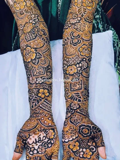 A complete view of the intricate bridal mehndi for Raazia. The design is packed with details, including floral patterns, geometric checks, and the bride's name beautifully written on the palm.