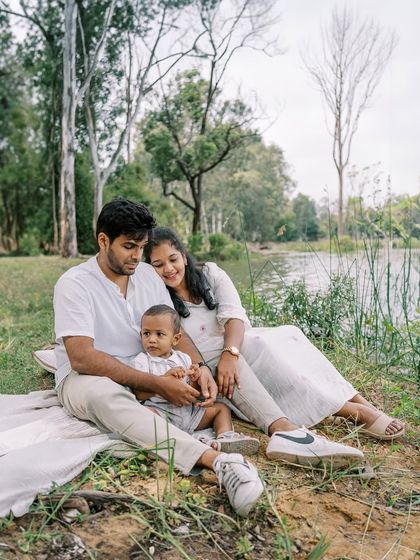 A family sitting by the lake, enjoying a quiet moment together. The serene landscape adds to the peaceful mood.
