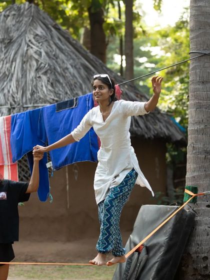 A participant learns to slackline with a helping hand. It's a perfect example of the supportive environment we create for trying new things.