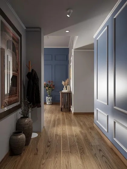 Even a hallway can make a statement. Here, I've used classic wall paneling in a contemporary blue, warm wooden flooring, and curated art and decor to create an elegant and welcoming passageway.