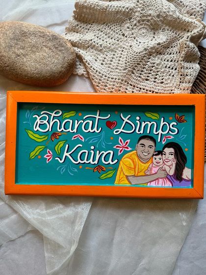 Another view of the custom family nameplate for Dimps, Bharat, and Kaira, showing how we integrate names and portraits into a single, cohesive design.