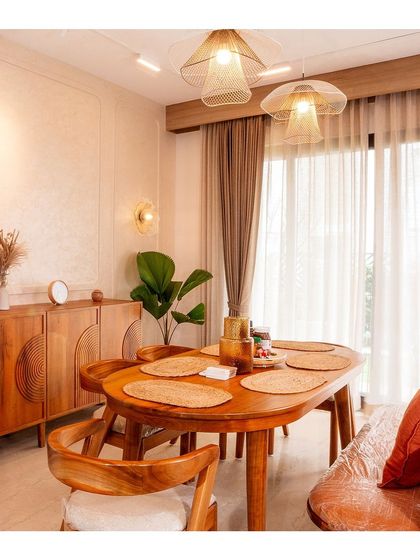 The dining area in the Japandi villa at NVT Stopping by the Woods, featuring a solid wood table, bench seating, and delicate woven light fixtures.