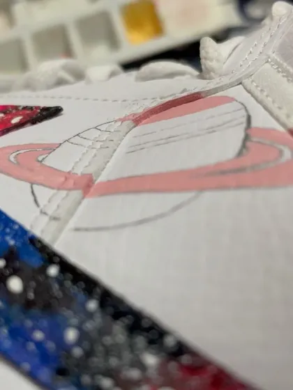 A process shot showing the first layers of paint for the Saturn design on our cosmic sneakers.
