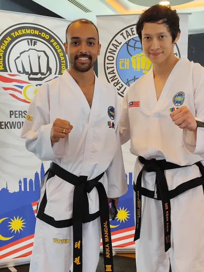 Our coach with a fellow black belt from Malaysia, a symbol of the global brotherhood of Taekwon-Do.