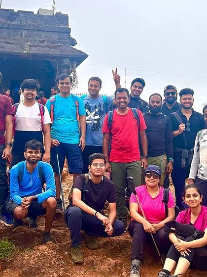 A group poses in front of a temple at a summit. Our treks often include cultural and historical sites, adding another layer to the experience.