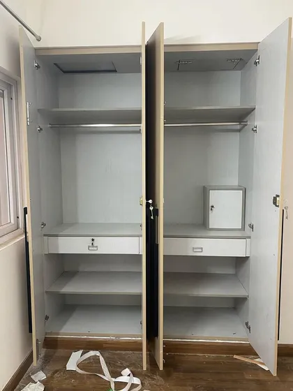 The internal view of a four-door wardrobe, showing a symmetrical layout with hanging space and drawers on both sides.