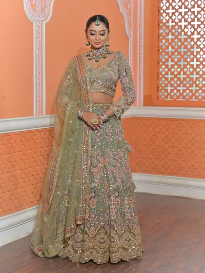 A full-length view of the bride in her pista green lehenga. This shows how the statement jewellery set complements the entire outfit, creating a balanced and elegant silhouette.