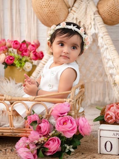 A serene moment in the wicker bassinet. The soft lighting and beautiful floral arrangements create a peaceful and dreamy portrait.