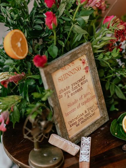 A close-up of the sign and vintage fan at the umbrella station, showcasing the blend of thoughtful details and rustic charm.
