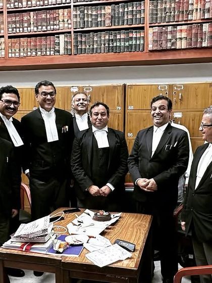 A group of smiling colleagues at ML Yadav's birthday celebration in the bar room. Recognizing the hard work of our peers is part of our professional culture.