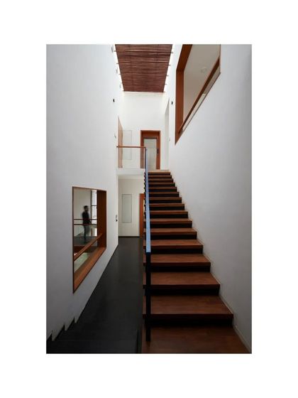 Another view of the wooden staircase in the Vikas Residence, showing its clean, minimalist lines and the warm texture of the wood.