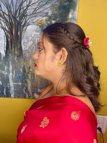 A modern take on a traditional hairstyle. I created a side braid leading into soft curls and added a single red flower for a pop of color.