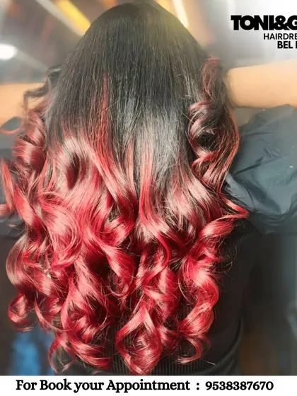 A fiery red ombre that makes a powerful statement. We achieved this vibrant look by carefully blending a deep root into bright, curled ends, ensuring the hair remains healthy and full of life.