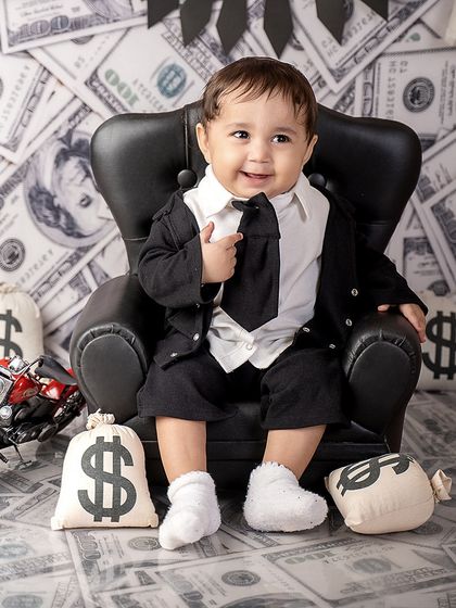 A happy little boss baby, ready to take on the world. His smile and confident pose make this money-themed shoot extra special.