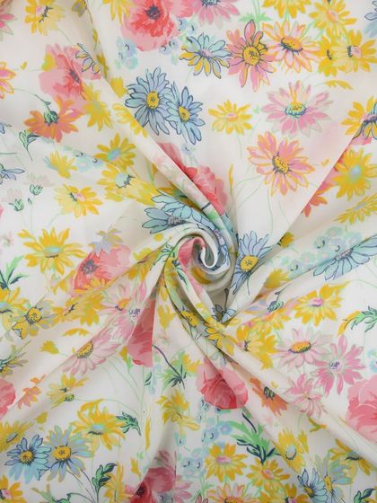 A pastel-colored floral fabric swirled to showcase its soft drape and delicate print.