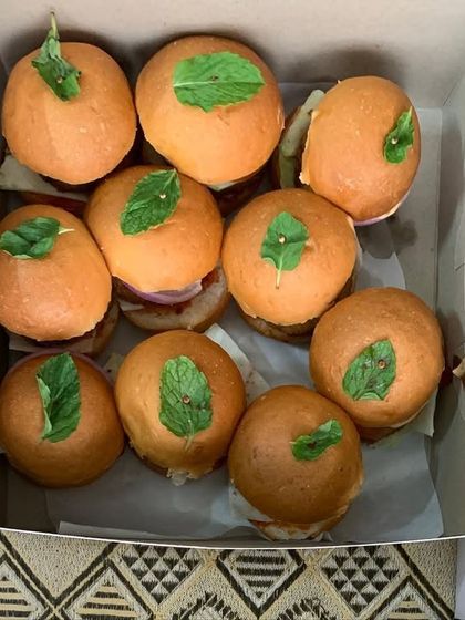A box of freshly made mini veggie burgers, part of a large order for a school picnic. It was a busy Friday, but serving happiness is always worth it.