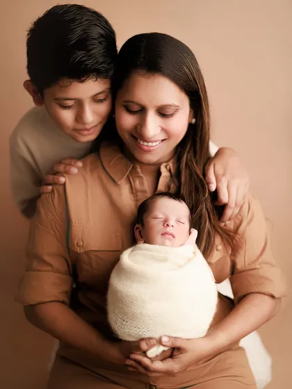 A mother's love, a brother's pride. This touching portrait shows a mother and her older son lovingly gazing at the newest addition to their family.
