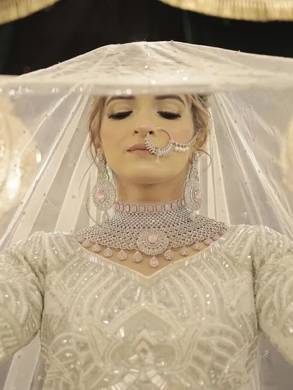For this bride, we created an ethereal and soft look to complement her elegant white wedding attire. The focus was on luminous skin, subtle contouring, and delicate eye makeup to create a timeless and graceful bridal style.