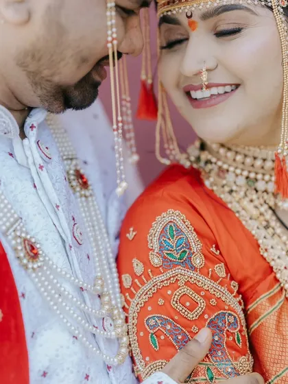 A close-up shot focusing on the bride's joyful expression and the intricate embroidery on her blouse during a Maharashtrian wedding.