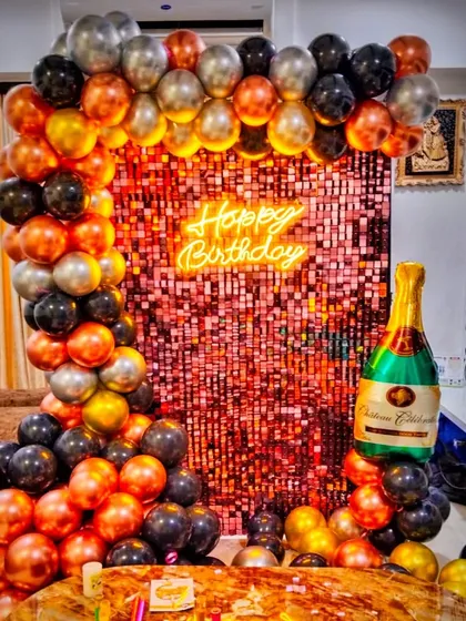 Another angle of the stylish adult birthday decoration. This view shows how the balloon arch and sequin wall create a contained, high-impact party corner within a living room space.