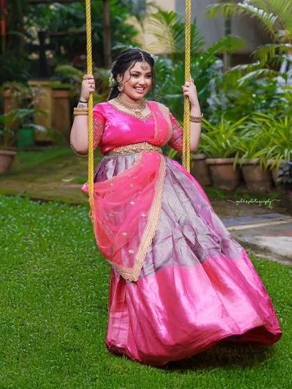 Another angle of the bride on the swing, this time showing the full sweep of her lehenga. It's a dynamic and fun shot.