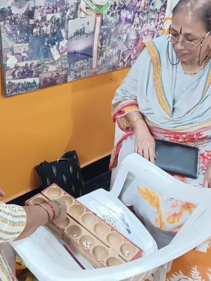 An educator demonstrating how to use the traditional game of Palanguzi in a workshop focused on innovative teaching methods.