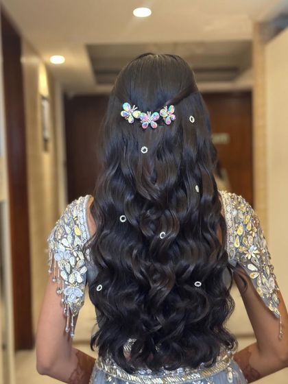 Soft waves are given a whimsical touch with scattered pearl clips and a beautiful butterfly accessory. This is a fun and dreamy look for a Sangeet or Mehendi.