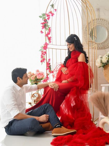 A romantic couple's portrait in our boho-inspired birdcage chair setup. The vibrant red gown provides a beautiful contrast to the bright, airy feel of the set.
