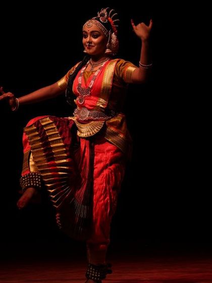 A solo dancer captured in a dynamic pose, her energy radiating from the stage during the Sadhana Classical Dance Festival.