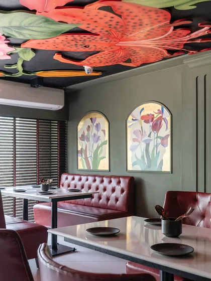 I believe ceilings are canvases waiting for a story. For this restaurant, I created a modern fresco of vibrant, oversized lilies and botanicals, turning the space above into a lush, dramatic garden that diners can get lost in.