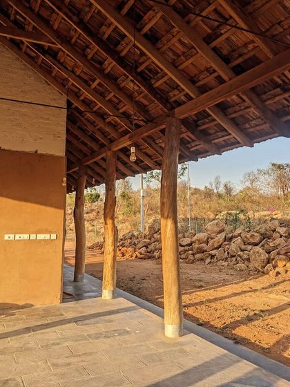 The veranda of the Unnathi Farm pavilion, with its reclaimed timber posts and stone flooring, looks out onto the rugged landscape.