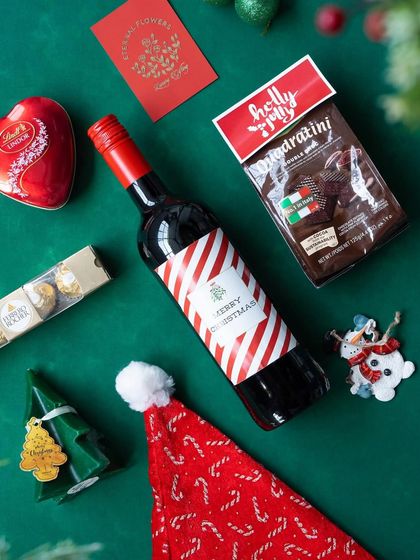 The contents of the 'Jolly Feast' hamper laid out on a green background, ready for gifting.