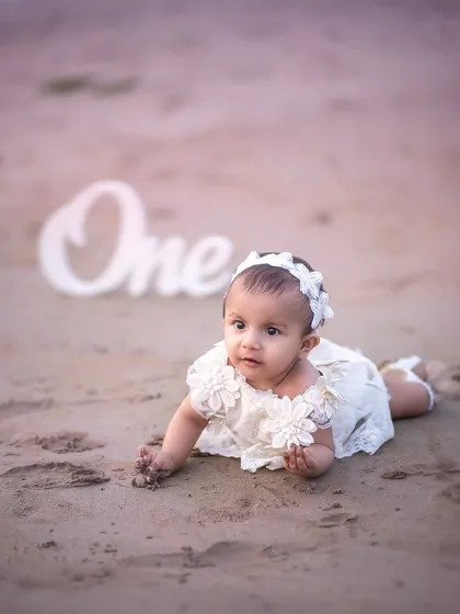 On the move! Capturing a baby's first explorations on the sand is a perfect way to document their growing independence during a first birthday shoot.