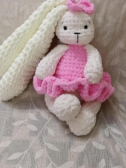 Made with super-soft, thick yarn, this long-eared bunny in a pink dress is designed to be extra floppy and cuddly.