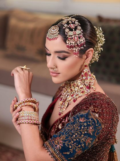 This shot highlights the beautiful hand and wrist jewelry, with the makeup providing a flawless canvas in the background.