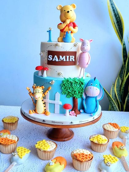 A cheerful Winnie the Pooh cake with matching cupcakes and cakesicles. I teach how to model Pooh and his friends, and how to create the honeycomb texture on the treats.