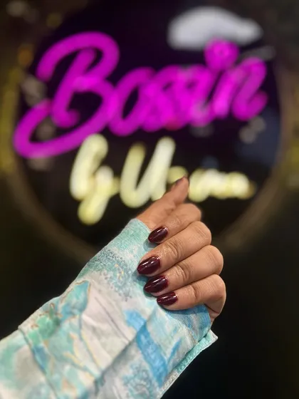 A side profile of the deep red manicure, showing the flawless application and high-shine finish of the gel polish.
