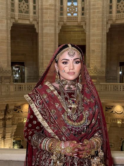 A frontal view of this majestic bridal look. The makeup was kept classic and clean to balance the heavy, traditional red velvet outfit and heritage jewelry.