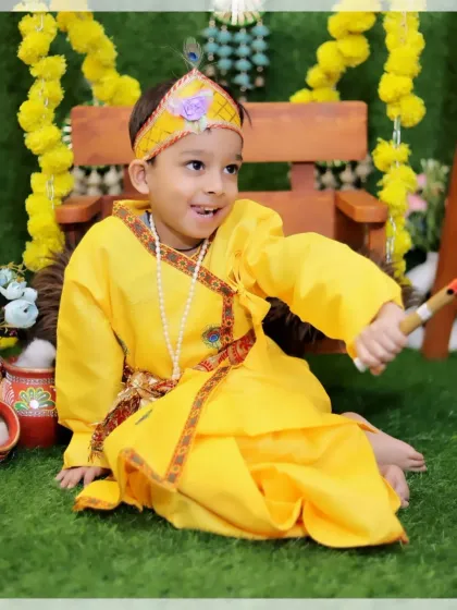 An older brother dressed as Krishna, sharing a happy moment during a sibling photoshoot. We cater to children of various ages for our themed sessions.