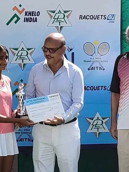 A young female player is awarded her trophy at the National tournament.