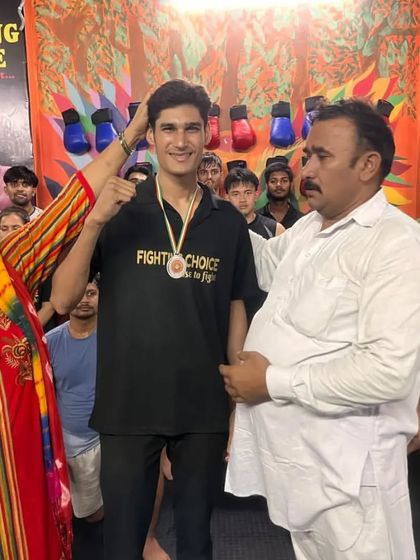 A fighter celebrates his win at the Taj Cup Wushu Championship with his family in the gym.