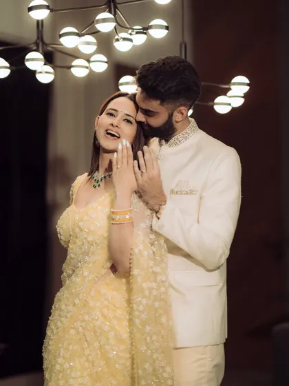 A moment of pure joy and laughter during an indoor engagement celebration. The warm lighting and genuine expressions make this a perfect blend of candid emotion and cinematic style.