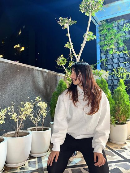 A side profile in the hoodie. The city lights in the background create a cool, urban atmosphere.