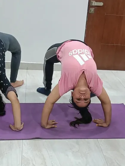 Two young students practicing the wheel pose at home. It's so rewarding to see children discover their strength and flexibility through yoga in a fun, supportive environment.